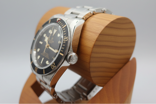 Watch on a wooden display stand with gray cushion