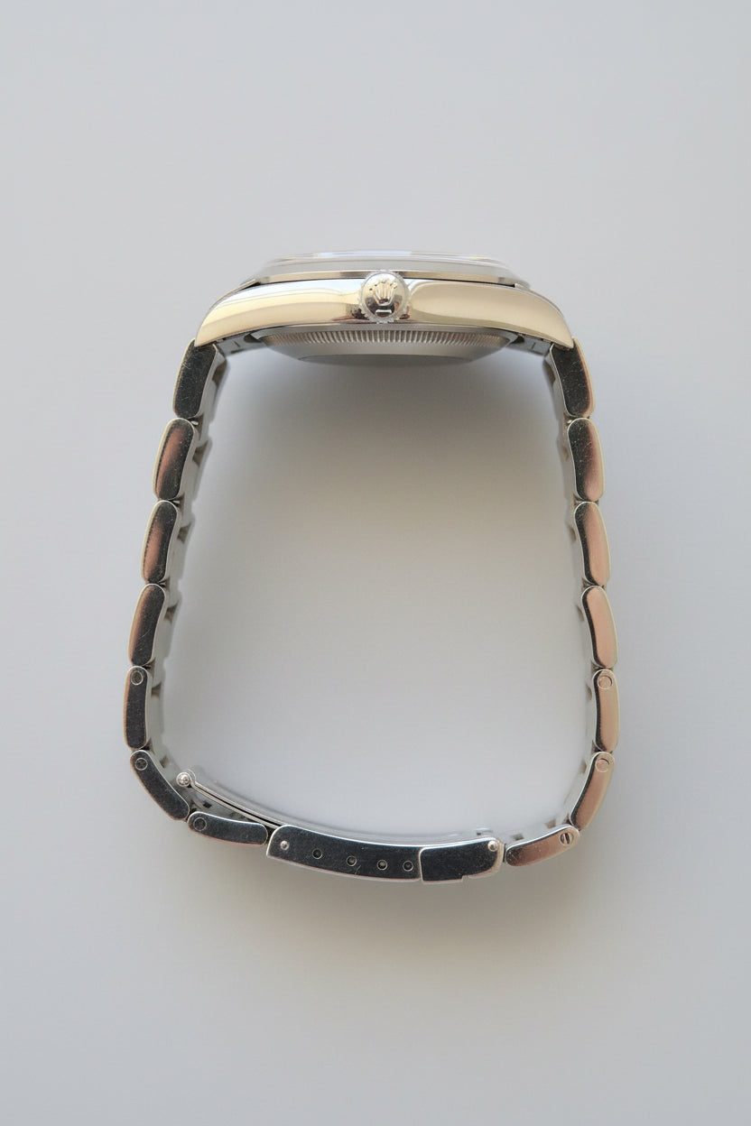 Silver watch with a metallic band on a dark gray background