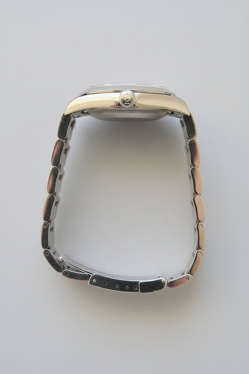 Silver watch with a metallic band on a dark gray background